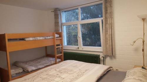 a bedroom with a bunk bed and a window at Ferienwohnung mit extra Schlafzimmer und Blick in den Bayrischen Wald oberhalb von Sankt Engelmar in Sankt Englmar