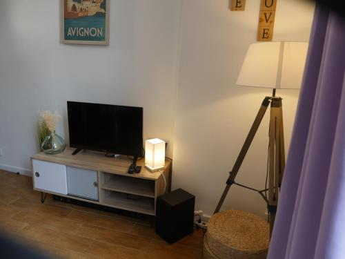 a living room with a flat screen tv and a lamp at Appartement AvignonMaProvence in Avignon