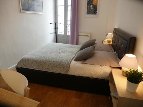 a bedroom with a large bed with pillows on it at Appartement AvignonMaProvence in Avignon
