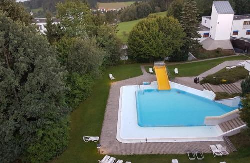 een uitzicht over een zwembad in een tuin bij Ferienwohnung mit extra Schlafzimmer und Blick in den Bayrischen Wald oberhalb von Sankt Engelmar in Sankt Englmar