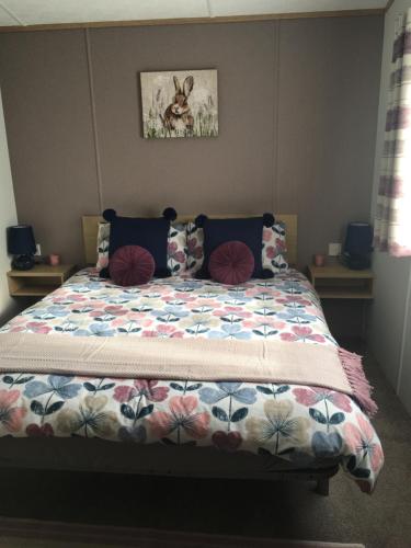 a bed with a quilt on it in a bedroom at Woodberry (Acorn Caravan Holidays Newquay) in Crantock