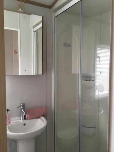 a bathroom with a sink and a glass shower at Woodberry (Acorn Caravan Holidays Newquay) in Crantock