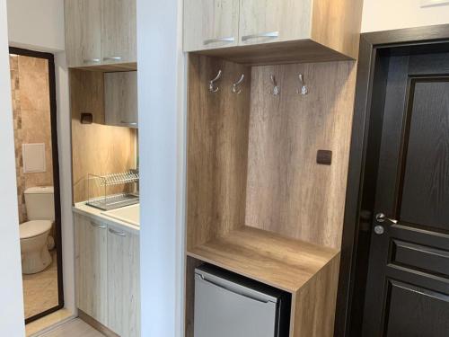a bathroom with wooden cabinets and a toilet and a door at Welcome home in Stara Zagora