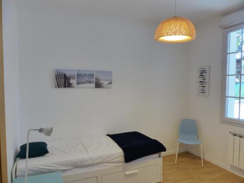 1 dormitorio con cama, lámpara y silla en Villa Mitoyenne Pour 4 Personnes Proche Centre-Ville D hossegor, en Hossegor