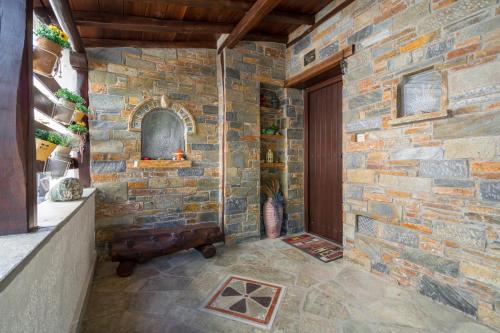 a room with a stone wall and a door at Villa Begonia by the sea in Koropi