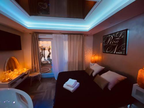 サルグミーヌにあるLe Rêve d'une Nuit suite Amourのベッドルーム(黒いベッド1台付)、バスルームが備わります。