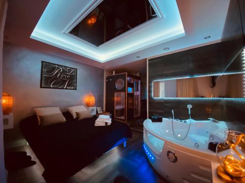 a large bathroom with a tub and a bed at Le Rêve d'une Nuit suite Amour in Sarreguemines