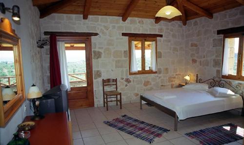 una camera con letto, tavolo e sedie di Villa Belvedere - Best panoramic sea view apts a Vasilikós