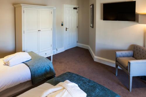 a hotel room with a bed and a chair and a tv at The Borough Lancaster in Lancaster