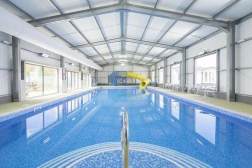 a large swimming pool with a yellow paddle in it at PRIVATELY OWNED Stunning Caravan Seawick Holiday Park St Osyth in Jaywick Sands