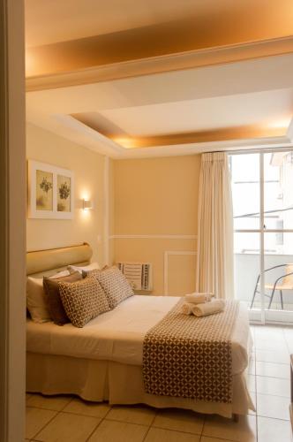 a bedroom with a bed and a large window at Hotel Village Icaraí in Niterói