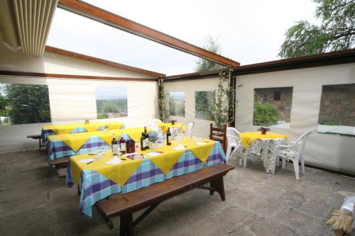 a patio with tables with yellow and blue tablecloths at Agriturismo Palazzo Bandino - Wine cellar, on reservation restaurant and spa in Chianciano Terme