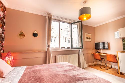a bedroom with a bed and a window and a desk at Luxury Suites Boutique by Rikas Hotels in Antwerp
