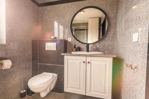 a bathroom with a toilet and a mirror at Luxury Suites Boutique by Rikas Hotels in Antwerp