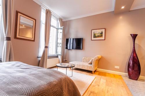 a bedroom with a bed and a couch and a tv at Luxury Suites Boutique by Rikas Hotels in Antwerp