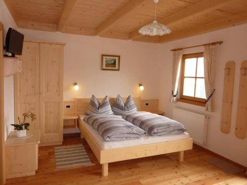 una camera da letto con un letto con cuscini sopra di Kerschbaumhof a San Candido