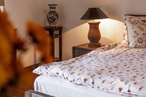 a bedroom with a bed and a lamp on a table at Casa Schmidt in Criţ