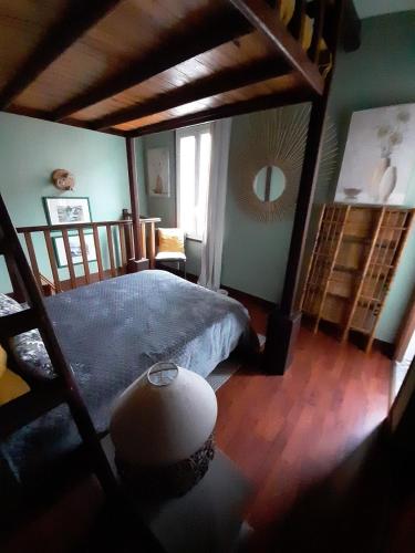 une chambre avec un grand lit et un miroir dans l'établissement Joli petit loft dans échoppe pierre centre-ville, à Bordeaux