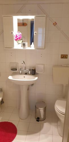 a white bathroom with a sink and a toilet at Vaso Studios in Vathi, Ithaka