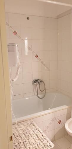 a white bathroom with a tub and a toilet at Vaso Studios in Vathi, Ithaka