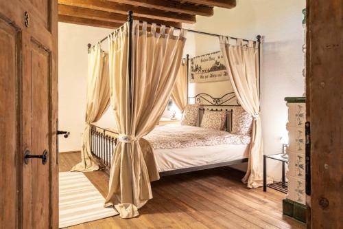 a bedroom with a canopy bed with curtains at Casa Schmidt in Criţ