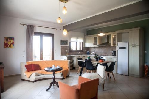 a living room and kitchen with a couch and a table at La Casa di Caterina: Nature,Relax and Private Garden in Lefkada Town