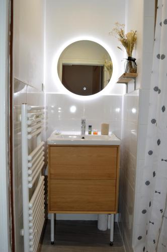 une salle de bain avec un lavabo et un miroir dans l'établissement - Le petit Rochelais - Centre Vieux Port, à La Rochelle
