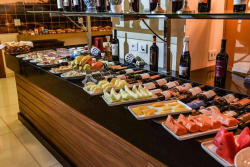 a buffet line with different types of food and bottles of wine at Hd Park Hotel in Assis