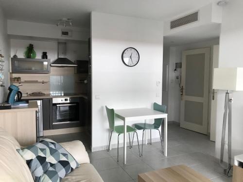 Il comprend une cuisine et un salon avec une table et des chaises. dans l'établissement Appartement Le Cosi 2 -bord de mer-, à La Ciotat