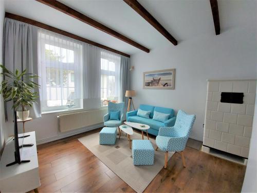 a living room with a blue couch and chairs at Villa Meeresglück in Sassnitz