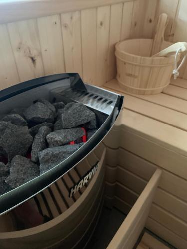 a bin full of rocks in a sauna at LUXURY VILLA M NEAR 2km AWAY FROM BITOLA WITH PRIVATE SWIMMING POOL & SAUNA &JACUZZI in Bitola