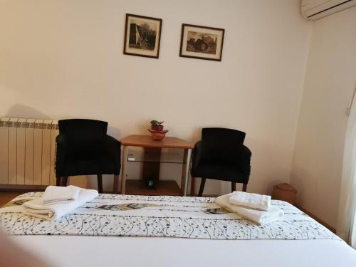 a room with two beds and two chairs at Guesthouse Vukasevic in Virpazar