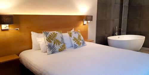a bedroom with a bed with a tub and a sink at Hotel Côté Cour in Durbuy