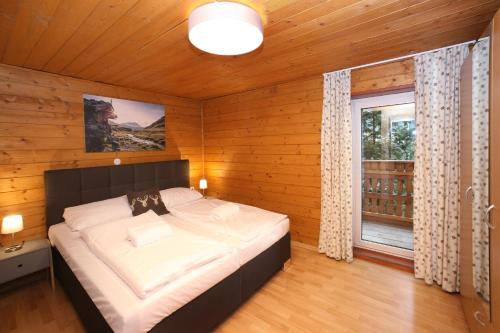 ein Schlafzimmer mit einem großen Bett in einem Holzzimmer in der Unterkunft Chalet Edelweiss in Zell am See