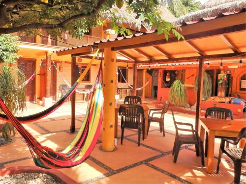 a patio with a hammock and tables and chairs at Hotelito Swiss Oasis - Solo Adultos in Puerto Escondido