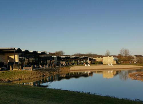 a pond in front of a building with swans in it at Resort Land & Zee in Scharendijke