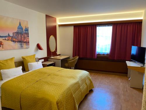 una camera d'albergo con letto e TV di Hotel Casino a Sierre