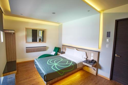 a bedroom with a bed and a chair and a mirror at Hotel Lirio - Adult Only in Mexico City