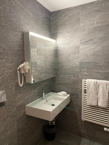 La salle de bains est pourvue d'un lavabo et d'un miroir. dans l'établissement Hotel Casino, à Sierre