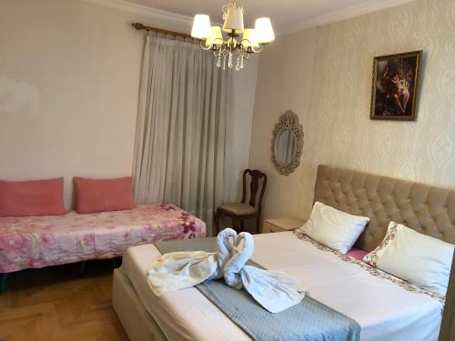una camera con due letti, un divano e un lampadario a braccio di Aparment on Nano a Tbilisi City