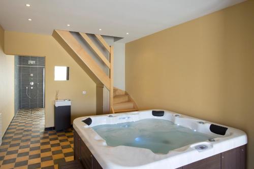 a large bath tub in a bathroom with a staircase at Holiday Home De Maalderij in Diksmuide