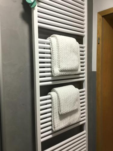 two white towels are hanging in a closet at Ferienwohnung Weisbrod, nur private Buchungen in Bräunlingen