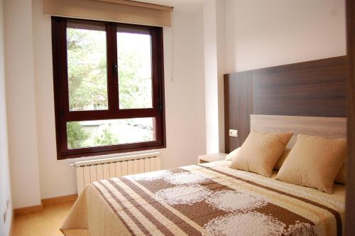 ein Schlafzimmer mit großem Bett und Fenster in der Unterkunft Gestiona2R - Apartamento 3 Habitaciones Landaburu in Posada de Llanes
