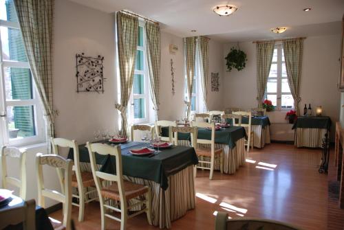 una sala da pranzo con tavoli, sedie e finestre di Posada Sarigarri ad Abaurrea Baja