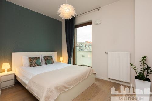 a bedroom with a white bed and a green wall at JM Millennium Port in Warsaw