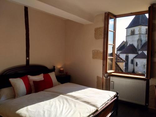 - une chambre avec un grand lit et une fenêtre dans l'établissement Chez Casimir, à Cercy-la-Tour
