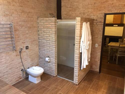 a bathroom with a toilet and a glass shower at Estalagem Wiesbaden in Monte Verde