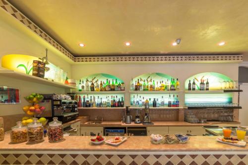 a kitchen with a counter with a lot of bottles at Hotel Airone in Bibione