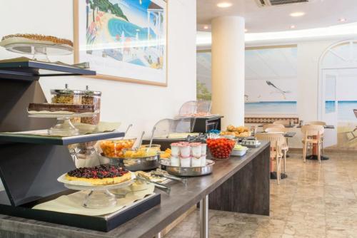 a buffet line with food on it in a restaurant at Hotel Airone in Bibione