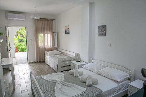 a hotel room with two beds and a hallway at Aelia Sea View Studios in Afitos